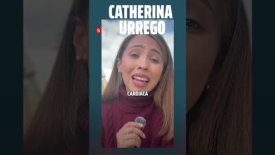 Primer plano de una mujer hablando a cámara con expresión emotiva y la boca entreabierta mientras sostiene un micrófono de solapa con esponjita, viste un suéter de cuello alto granate sobre un fondo exterior con cielo nublado y texto superpuesto en mayúsculas en la parte superior y central junto a un pequeño logotipo rojo, Ventajas y desventajas del 102 años plus sport: ¿vale la pena?