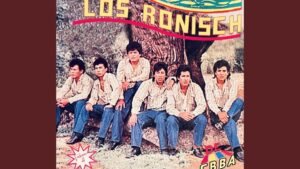 Portada retro que muestra a seis hombres sentados en fila frente a un tronco y un paisaje exterior, vestidos con camisas a rayas claras y vaqueros, con expresión seria y tipografías coloridas en los bordes, evocando una escena musical vintage y planteando un enfoque informativo y accesible sobre Voto a los 16 años ventajas y desventajas: ¿madurez o riesgo político?