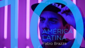 Retrato cercano de un hombre joven con gorra iluminado por luces neón púrpura y azul, sobre un gran gráfico circular y texto superpuesto que remite a América Latina y a un nombre artístico, con alta intensidad de contraste y composición moderna que sugiere temas sociales y culturales, Grupo social indios ventajas y desventajas: impacto y desafíos clave, optimizado para accesibilidad y búsqueda.