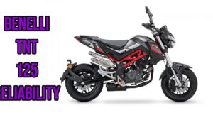 Perfil lateral de una motocicleta naked Benelli sobre fondo blanco que muestra chasis tubular rojo, escape doble elevando hacia atrás, carrocería gris y detalles negros y ruedas con freno de disco, acompañada de texto promocional en morado, Benelli TNT 150 ventajas y desventajas de esta moto ligera y potente