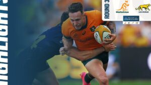 Fotografía de un jugador de rugby con camiseta naranja de los Wallabies que avanza con el balón mientras un defensor de camiseta oscura intenta placarlo, con logotipos del torneo y de Los Pumas en la esquina, Ventajas y desventajas TLC Chile Australia: impacto en comercio.