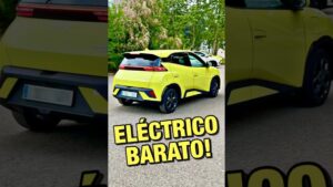 Fotografía de un coche eléctrico compacto de color amarillo verdoso tipo hatchback, aparcado en una calle con árboles de fondo y un gran rótulo superpuesto que dice ELÉCTRICO BARATO!, acompañada de la frase Ventajas y desventajas de los coches eléctricos: ¿realmente convienen? como gancho informativo