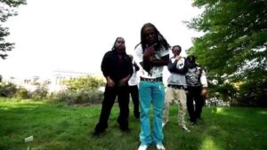 Grupo de jóvenes con estética urbana posando en un parque con césped y árboles, figura central con pantalones turquesa y trenzas largas, poses de actitud y luz natural que crean contraste y enfoque visual, ideal como imagen destacada para acompañar análisis y contenidos informativos Ventajas y desventajas del TLC en Costa Rica: impacto y controversias