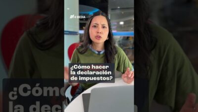 Mujer joven de expresión seria con camiseta verde sentada frente a un portátil en un entorno de oficina, gesticulando mientras explica la declaración de impuestos con texto sobreimpreso y logo editorial, Ventajas y desventajas del ITIN number: guía clave para inmigrantes.