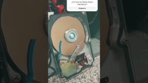 Imagen del interior abierto de un disco duro mecánico mostrando el plato reflectante, el brazo actuador y componentes electrónicos sobre una superficie de granito, ilustrativa para artículos técnicos y accesibles sobre almacenamiento y comparativas, Ventajas y desventajas disco mecánico y SSD: descubre cuál elegir