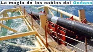 Vista de un buque especializado y su estructura metálica amarilla con pasarelas mientras se despliega un grueso cable submarino negro sobre el océano azul, mostrando la infraestructura física de la conectividad global y destacando las Ventajas y desventajas sobre el internet que impactan tu vida diaria