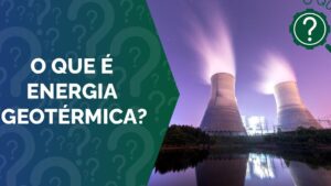 Vista nocturna de una planta con dos grandes torres de refrigeración que emiten vapor y se reflejan en un estanque, acompañada de un panel informativo que pregunta qué es la energía geotérmica; La energía geotérmica ventajas y desventajas: descubre su impacto real.