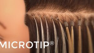 Primer plano de extensiones capilares tipo microtip fijadas con pequeñas argollas metálicas a mechones junto a la raíz, mostrando el método de aplicación y opciones estéticas, Extensiones con microring ventajas y desventajas para ti