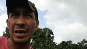 Primer plano de un hombre con gorra y semblante pensativo en un entorno rural con vegetación y cielo nublado, útil para ilustrar Suelo franco arenoso ventajas y desventajas para cultivar mejor