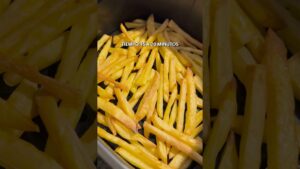 Primer plano de papas fritas doradas repartidas en la cesta de una freidora de aire con el texto superpuesto TIEMPO: 15 A 20 MINUTOS, Ventajas y desventajas freidora de aire: ¿vale la pena?