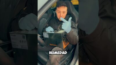 Persona con guantes azules sentada en el interior de un coche sostiene y señala un generador metálico de ozono apoyado en el regazo mientras en la imagen aparece la palabra HUMEDAD, Generador de ozono ventajas y desventajas: poder y riesgos clave