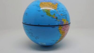 Globo terráqueo azul de sobremesa sobre fondo claro que muestra el hemisferio occidental con América del Norte y América del Sur en colores contrastantes, detalles de países y líneas de latitud, costura ecuatorial visible y sombra tenue, Ventajas y desventajas del globo terráqueo: descubre su impacto real