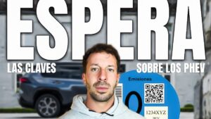 Retrato de un hombre con sudadera en primer plano frente a un SUV desenfocado y una etiqueta de emisiones azul, sobre un gran titular "ESPERA" y los subtítulos "LAS CLAVES" y "SOBRE LOS PHEV", imagen que invita a reflexionar sobre Ventajas y desventajas de un coche híbrido enchufable: ¿vale la pena?.