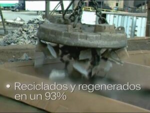 Imán electromagnético industrial levanta fragmentos de chatarra metálica en una planta de reciclaje con texto superpuesto "Reciclados y regenerados en un 93%", mostrando el proceso de recuperación de metales y contexto útil para temas de cocina y mantenimiento como Ollas de hierro fundido ventajas y desventajas para ti.