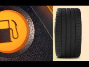 Imagen dividida que muestra a la izquierda un testigo de combustible iluminado en ámbar sobre el salpicadero texturizado y a la derecha la vista frontal de una llanta ancha con dibujo de la banda de rodamiento sobre fondo neutro, útil para ilustrar Ventajas y desventajas de llantas anchas para elegir bien.