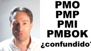 Imagen de un hombre con camisa blanca a la izquierda hablando frente a un fondo claro y a la derecha grandes letras negras con las siglas PMO, PMP, PMI y PMBOK junto a la palabra "¿confundido?", Ventajas y desventajas de la metodología PMI para tu proyecto