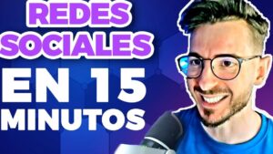 Miniatura de video llamativa con fondo azul y morado y grandes letras blancas que dicen "REDES SOCIALES EN 15 MINUTOS", mostrando a un presentador sonriente con gafas y micrófono en primer plano, diseñada para captar atención y optimizada para búsquedas sobre Redes sociales ventajas y desventajas ppt: lo que nadie te cuenta.