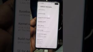 Teléfono inteligente sostenido con la mano y conectado por un cable mostrando la pantalla de información del software con campos de versión de Android, kernel y compilación, imagen optimizada para SEO y accesibilidad que ilustra un artículo titulado Ventajas y desventajas de rootear un celular: ¿vale la pena el riesgo?