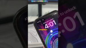 Primer plano de la pantalla de bloqueo de un smartphone con el operador AT&T y la instrucción "Swipe up to unlock", un fondo vibrante con anillos concéntricos y la palabra "compañías" en amarillo, descrita de forma accesible y optimizada para SEO: Ventajas y desventajas de la sim: descubre qué opción es mejor para ti