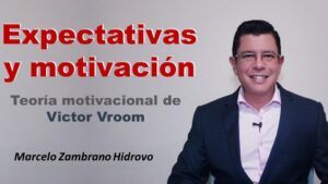 Miniatura didáctica sobre motivación con fondo gris y texto grande en rojo que dice Expectativas y motivación, subtítulo en tonos grises y azules que alude a la teoría motivacional de Vroom y a la derecha un presentador masculino sonriente con traje oscuro y micrófono de solapa, Ventajas y desventajas de la teoría de expectativas de Vroom